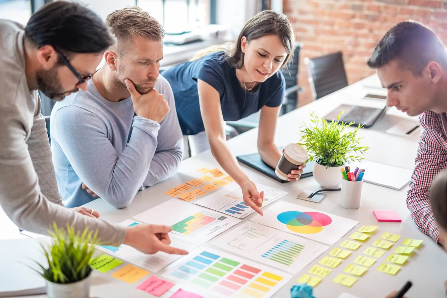 Group of people around a table with graphs and diagrams and post its