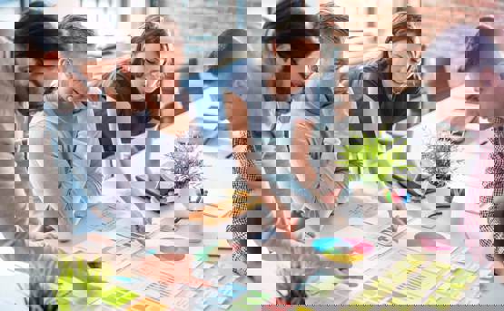 Group of people around a table with graphs and diagrams and post its