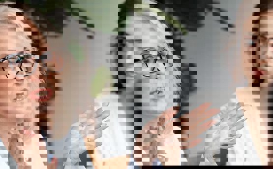 an older woman talks with hand movements to a younger woman