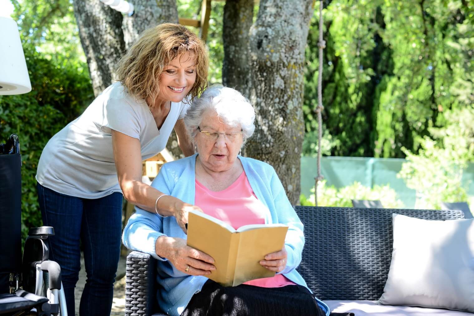 Woman reading with elderly woman 
