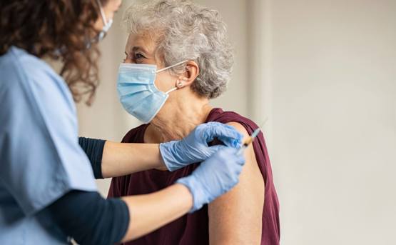 Nurse giving vaccine to senior woman 