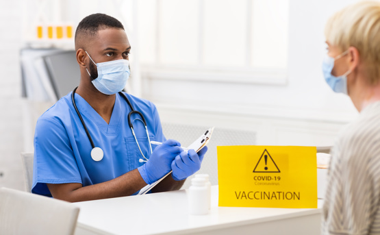 Male doctor registering patient for COVID-19 Vaccination 