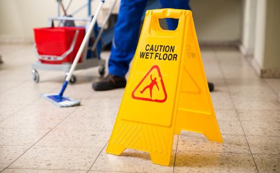 Image of wet floor safety sign with cleaner in background