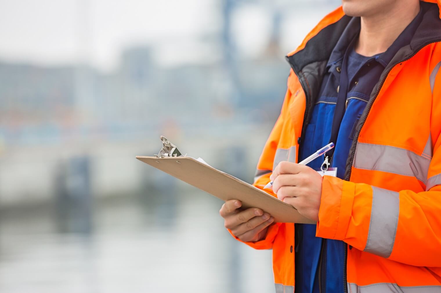 Stock image of man holding a clipboard wearing a high viz jacket