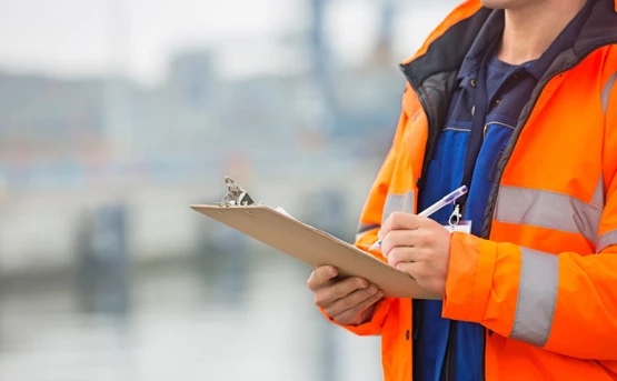 Stock image of man holding a clipboard wearing a high viz jacket