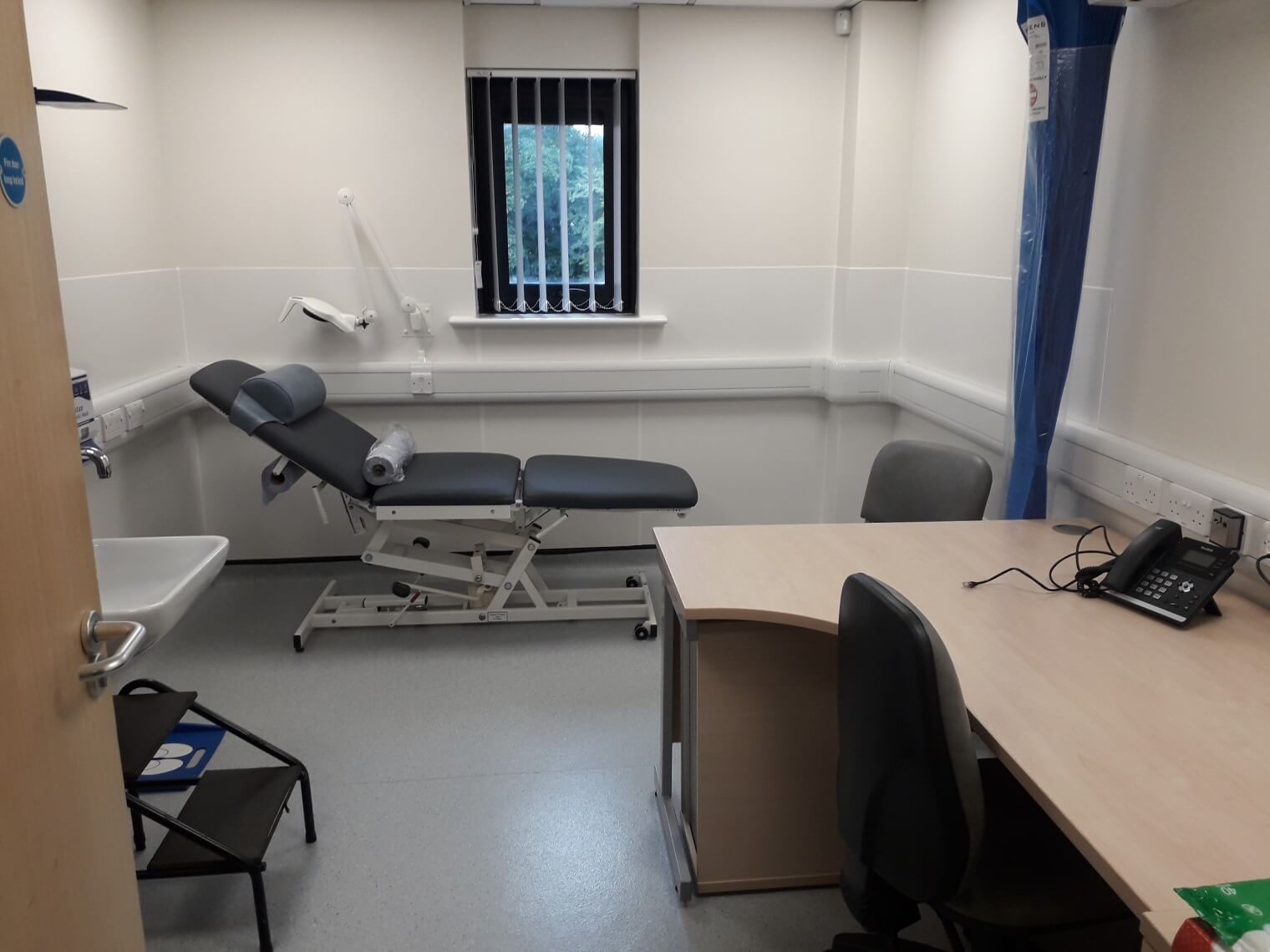 GP room with desk and bed