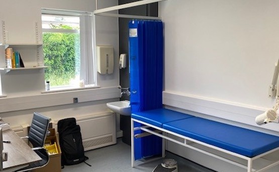 Clinical room with blue curtain and bed