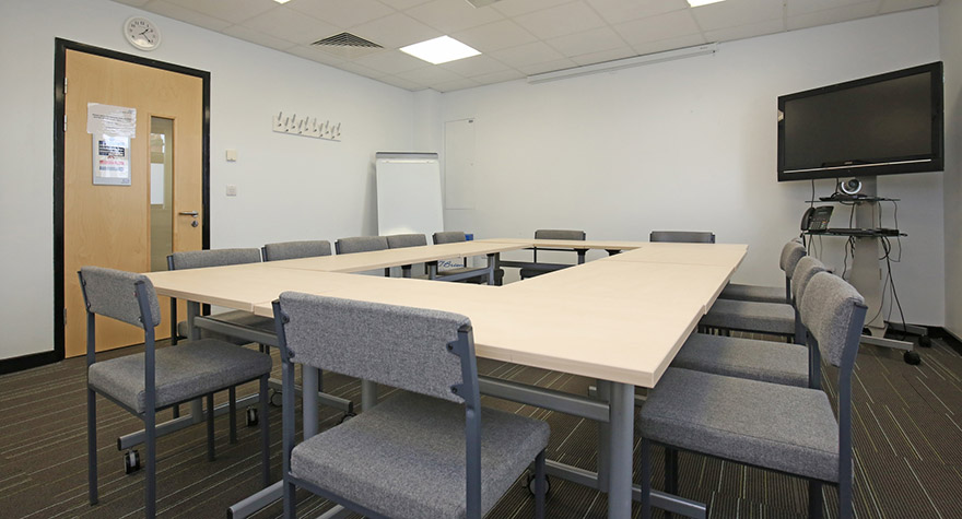 Meeting room with large table and lots of chairs around it