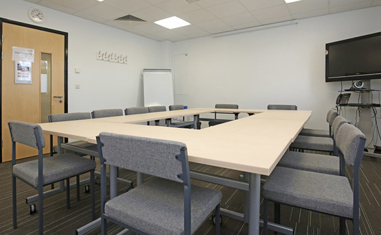 Meeting room with large table and lots of chairs around it
