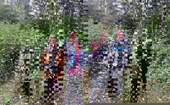 Six colleagues from People team volunteering in a woods with sheers 