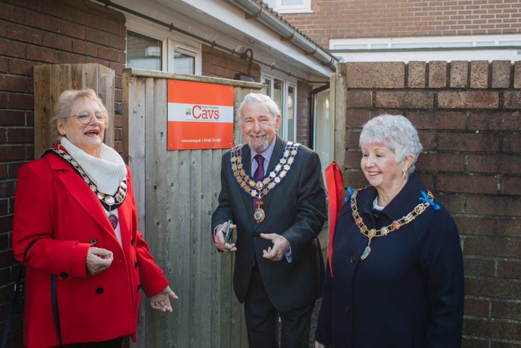 A group of three people chatting and laughing outside the new office premises for Castle Point Association of Voluntary Services (CAVS)