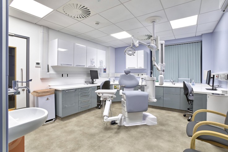 An examination room at the new Hythe and Dibden War Memorial Hospital. There's a grey reclining patient chair, filing cabinets, patient chairs and desks. 