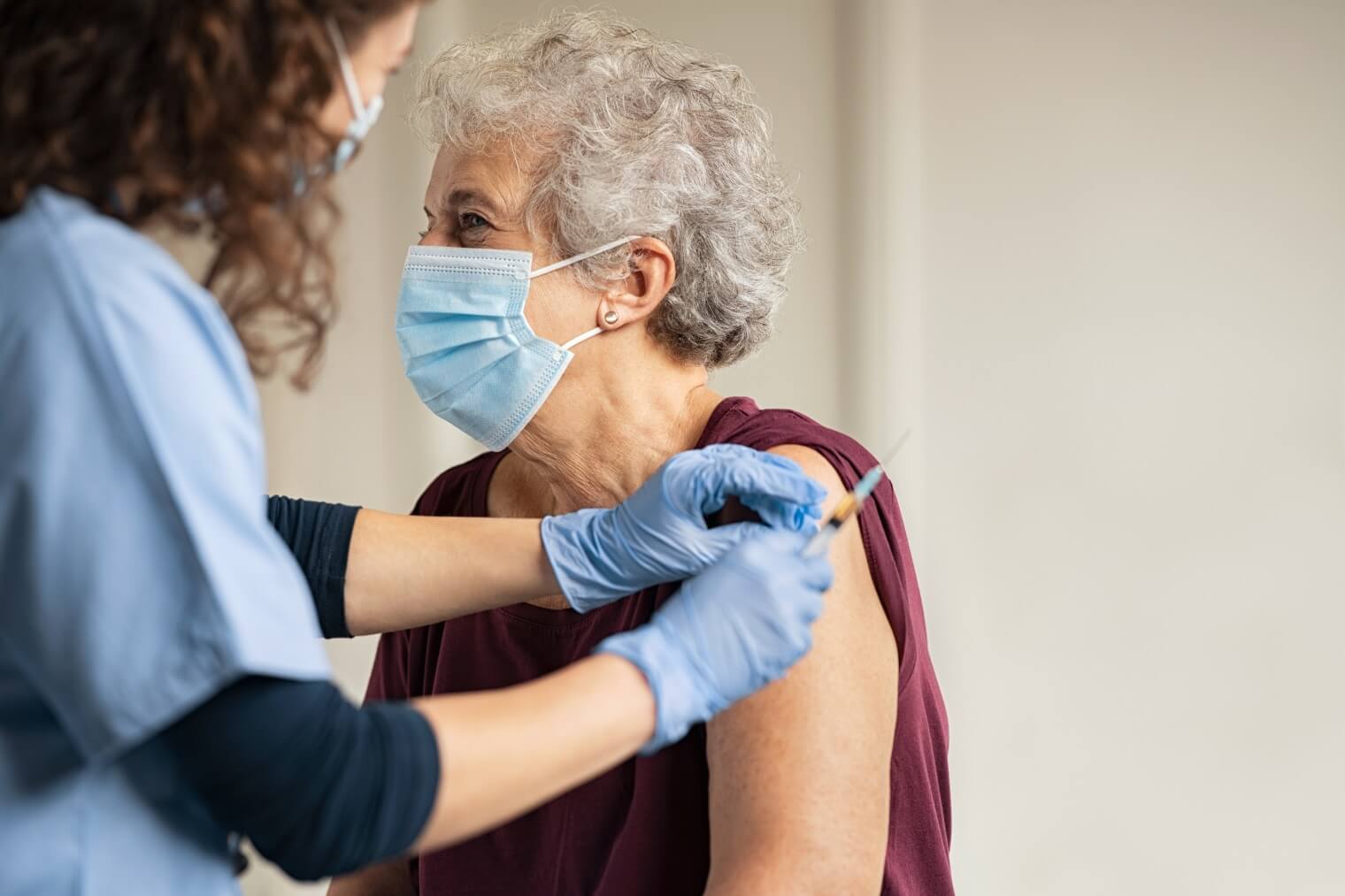 Nurse giving vaccine to senior woman 