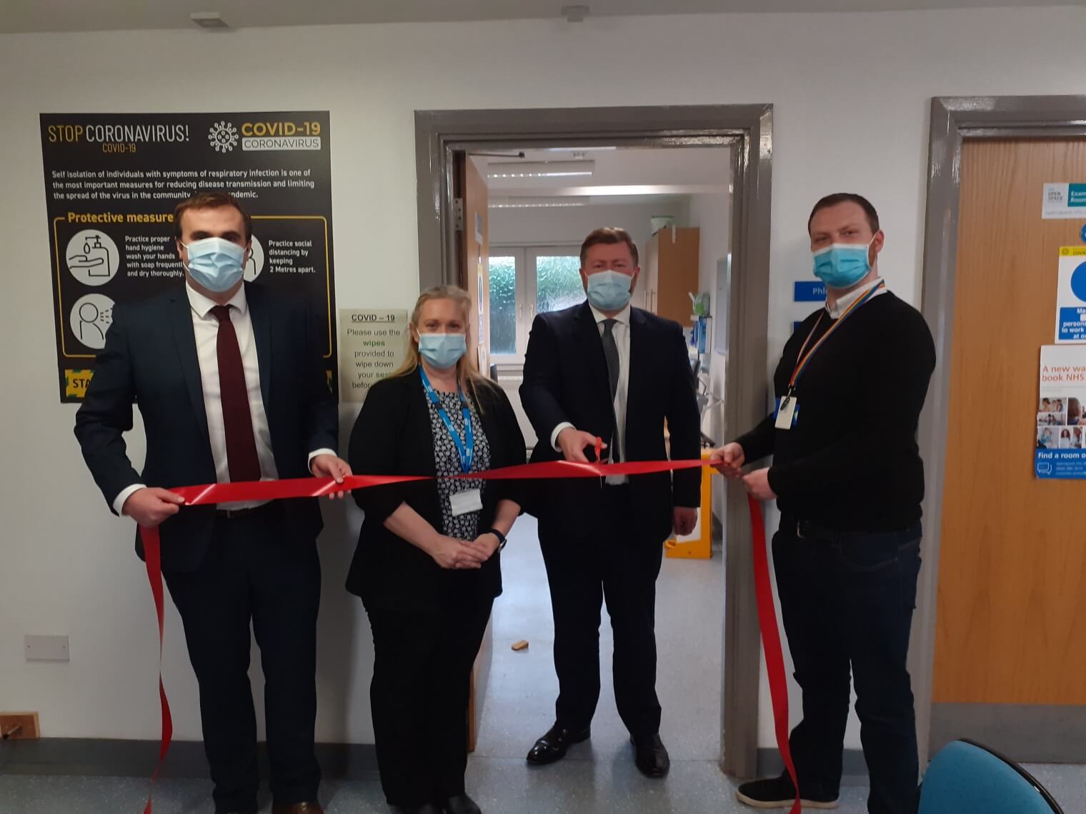 3 men and 1 woman ribbon cutting at Churchtown Health Centre